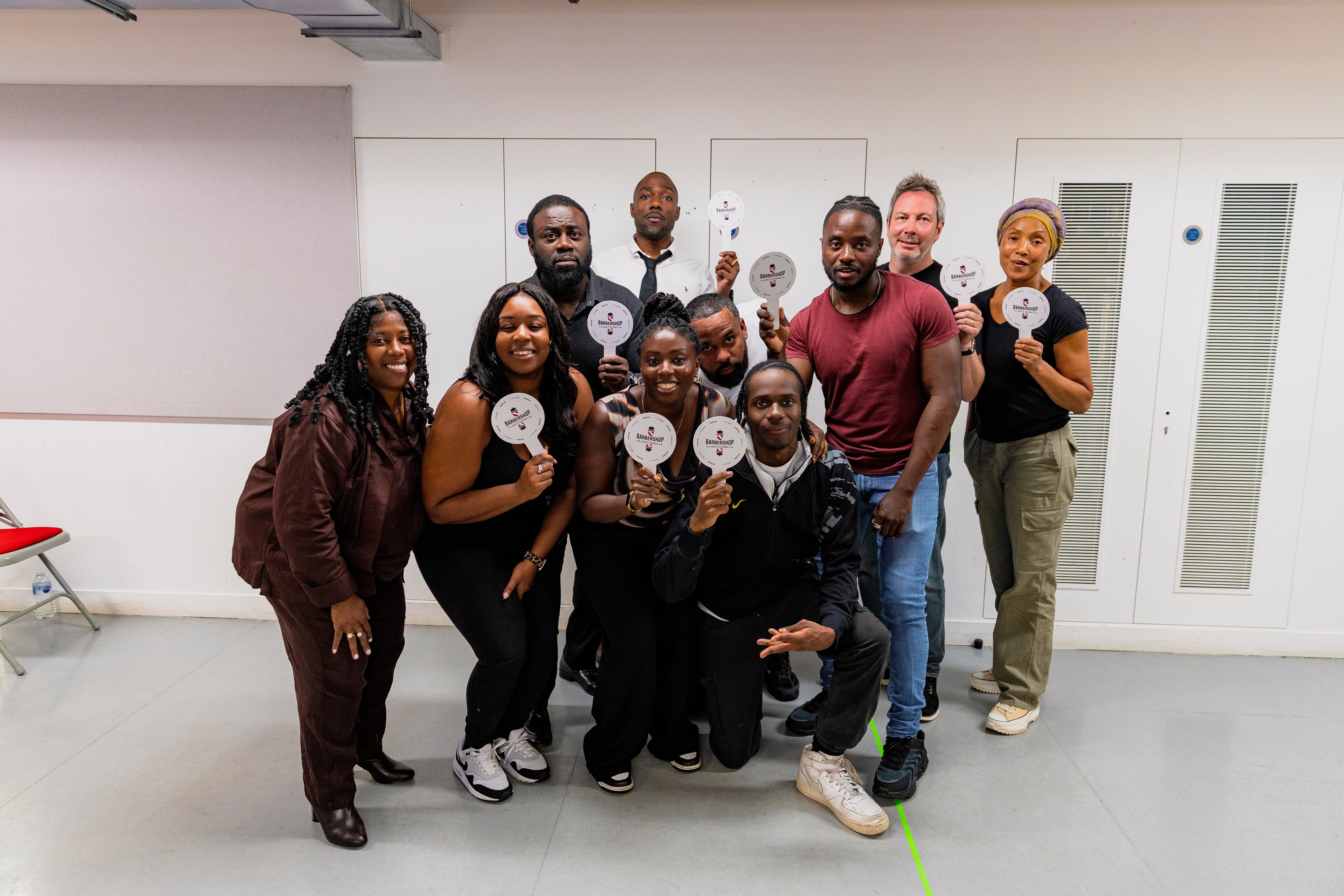 Full cast and creative team group photograph from rehearsals